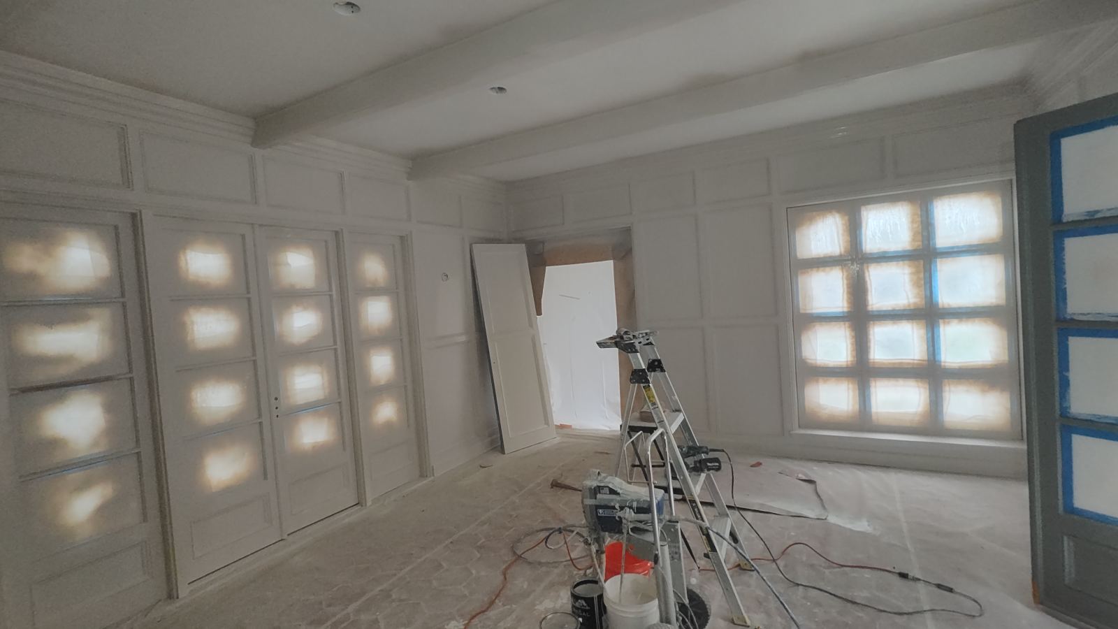 Paneled room masked off and prepped for paint spraying